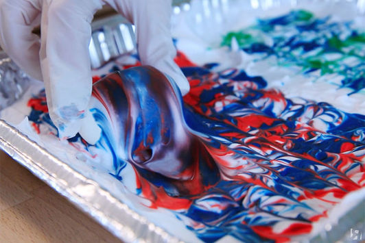 Надеваем перчатки. Берем яйцо и окунаем его в цветную пену, покрываем равномерно со всех сторон.